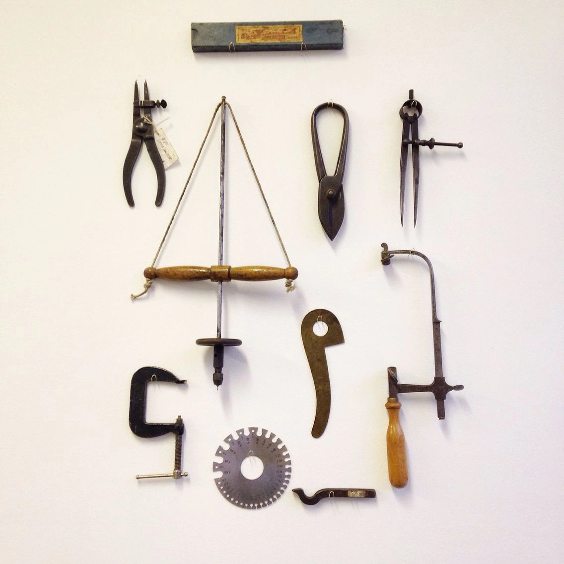 Metalworking tools on a near-white wall